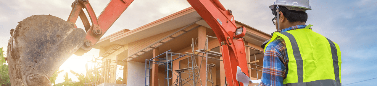 Image of a construction worker overlooking an excavator shows an example of a business that would need builders risk insurance.