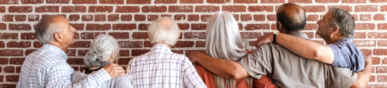 Multiple generations of a family with arms around each other showing an example of people who could benefit from life insurance in sc