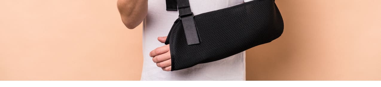 Workers compensation insurance claimant with injury to left arm shown in a sling.